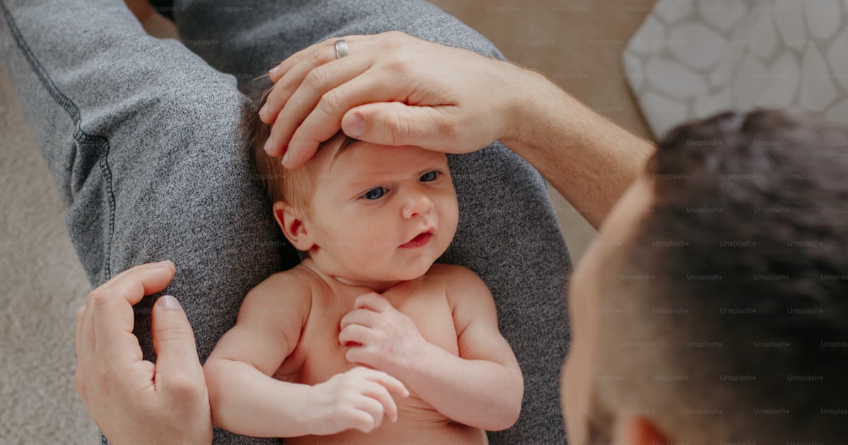 Happy Caucasian father holding newborn baby on laps knees. Man parent ...