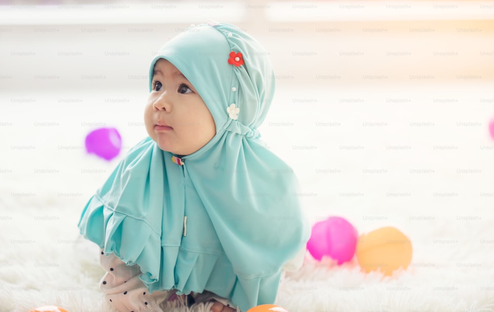 Muslim Baby plays with colorful toys in the living room.