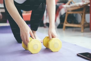 Closeup woman hands holding dumbell. The concept of a healthy lifestyle and fitness.