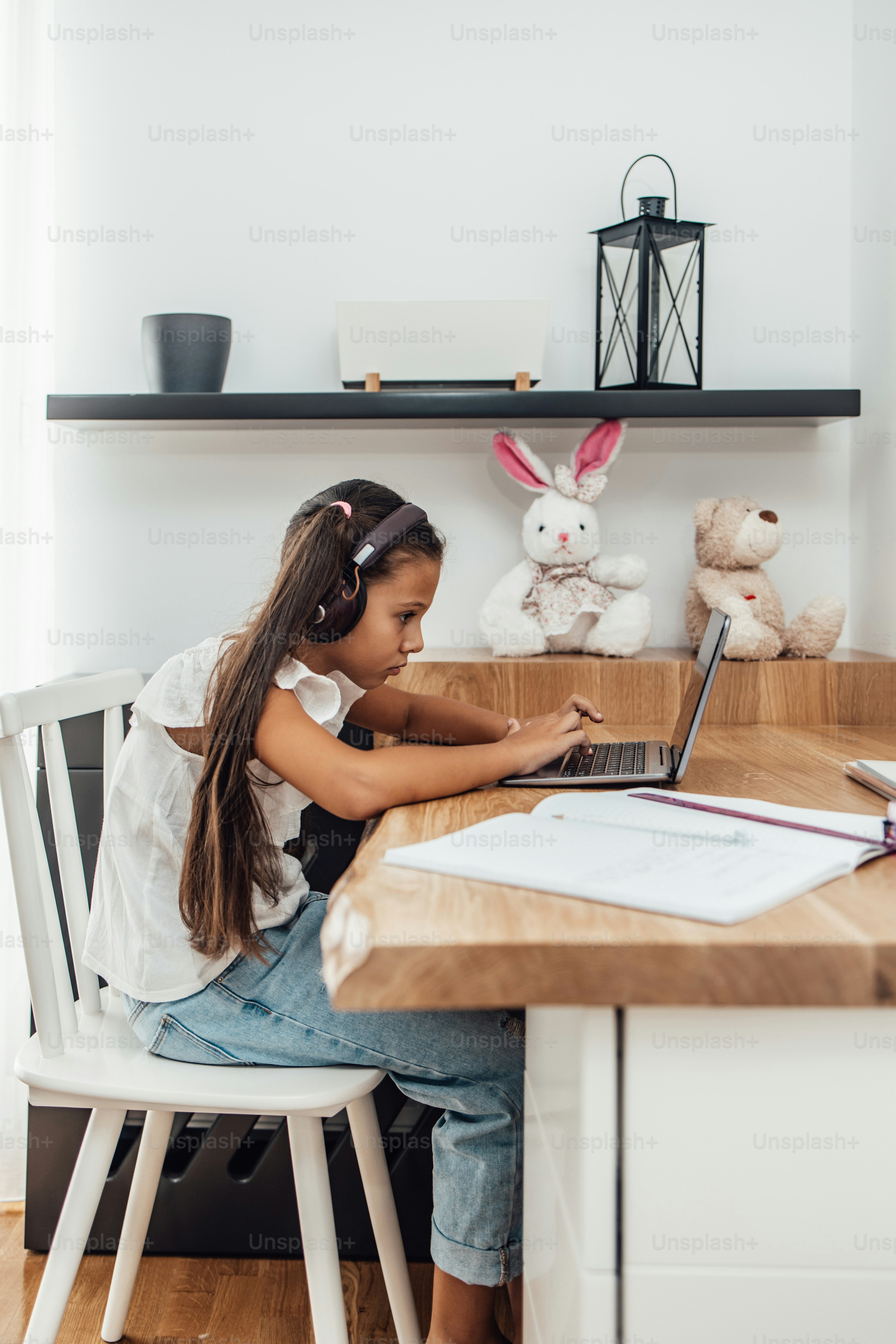 Giovane bambina che ha una sessione di e-learning durante la crisi pandemica di Covid-19, il blocco o la quarantena. Prevenzione delle malattie e concetto di nuova normalità.