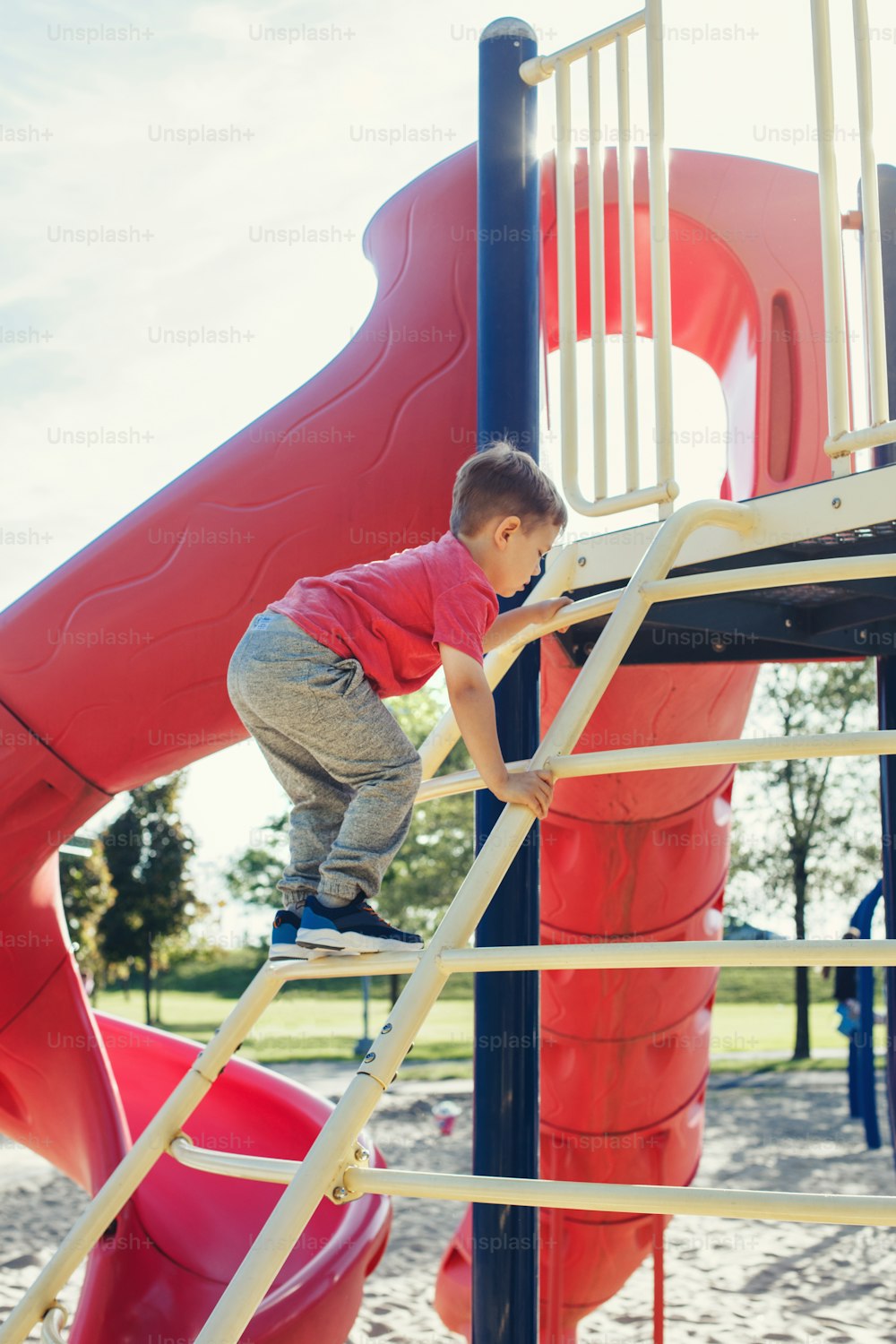 Active happy brave Caucasian boy child climbing staircase climber on playground schoolyard outdoor on summer sunny day. Seasonal kids activity outside. Authentic childhood lifestyle concept.