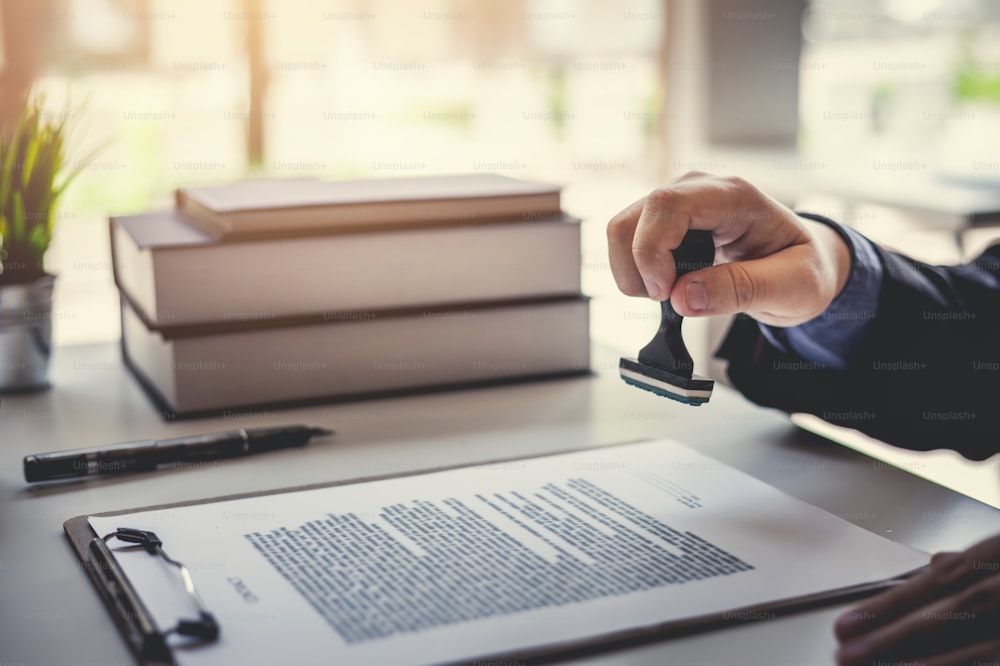 Businessman stamping with approved stamp on document contract.