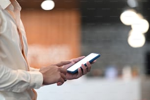 Cropped shot of a businessman hand pointing on mobile phone with white screen.