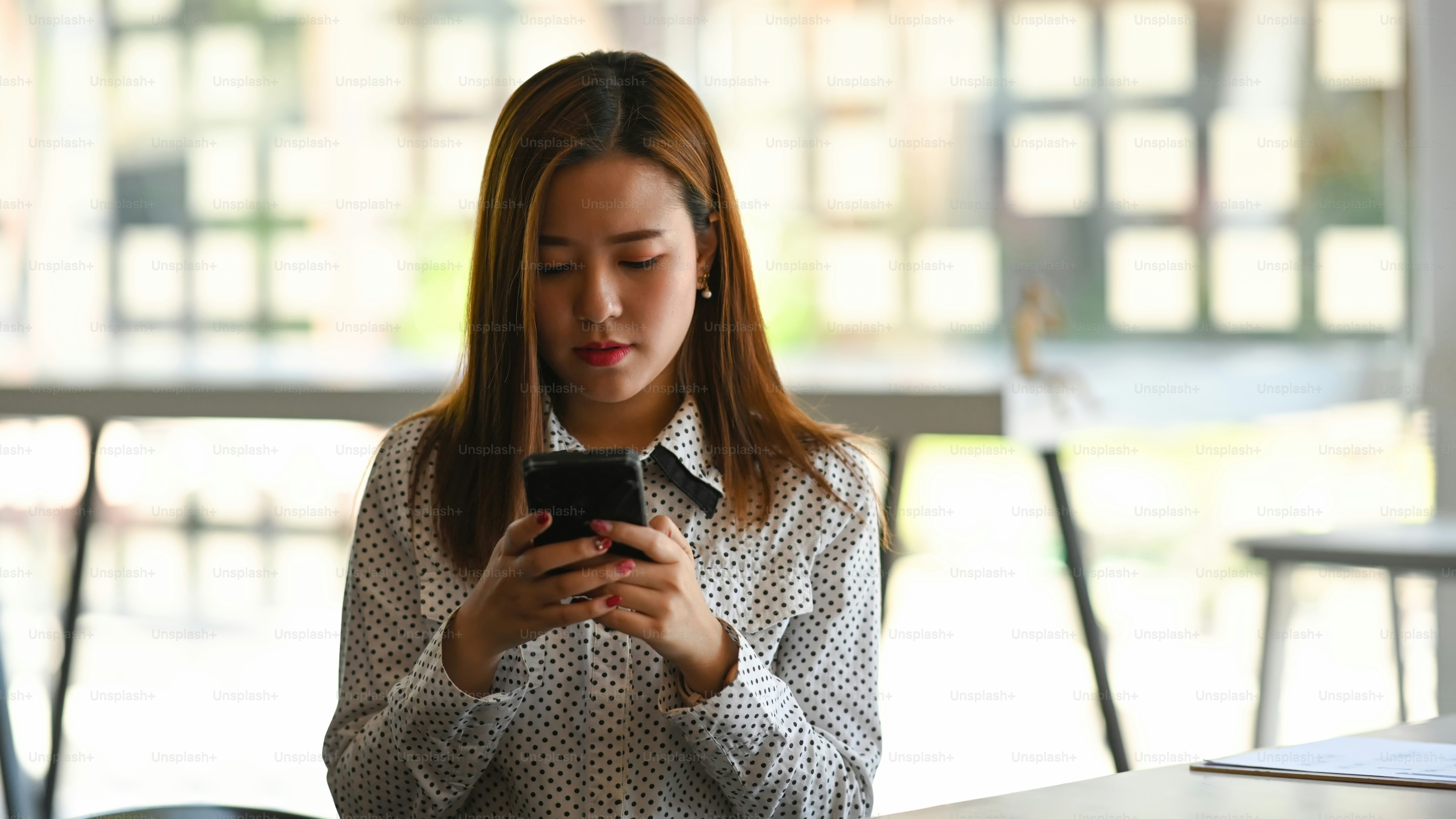 Portrait of a businesswoman concentrate on mobile phone and sitting at her workplace.