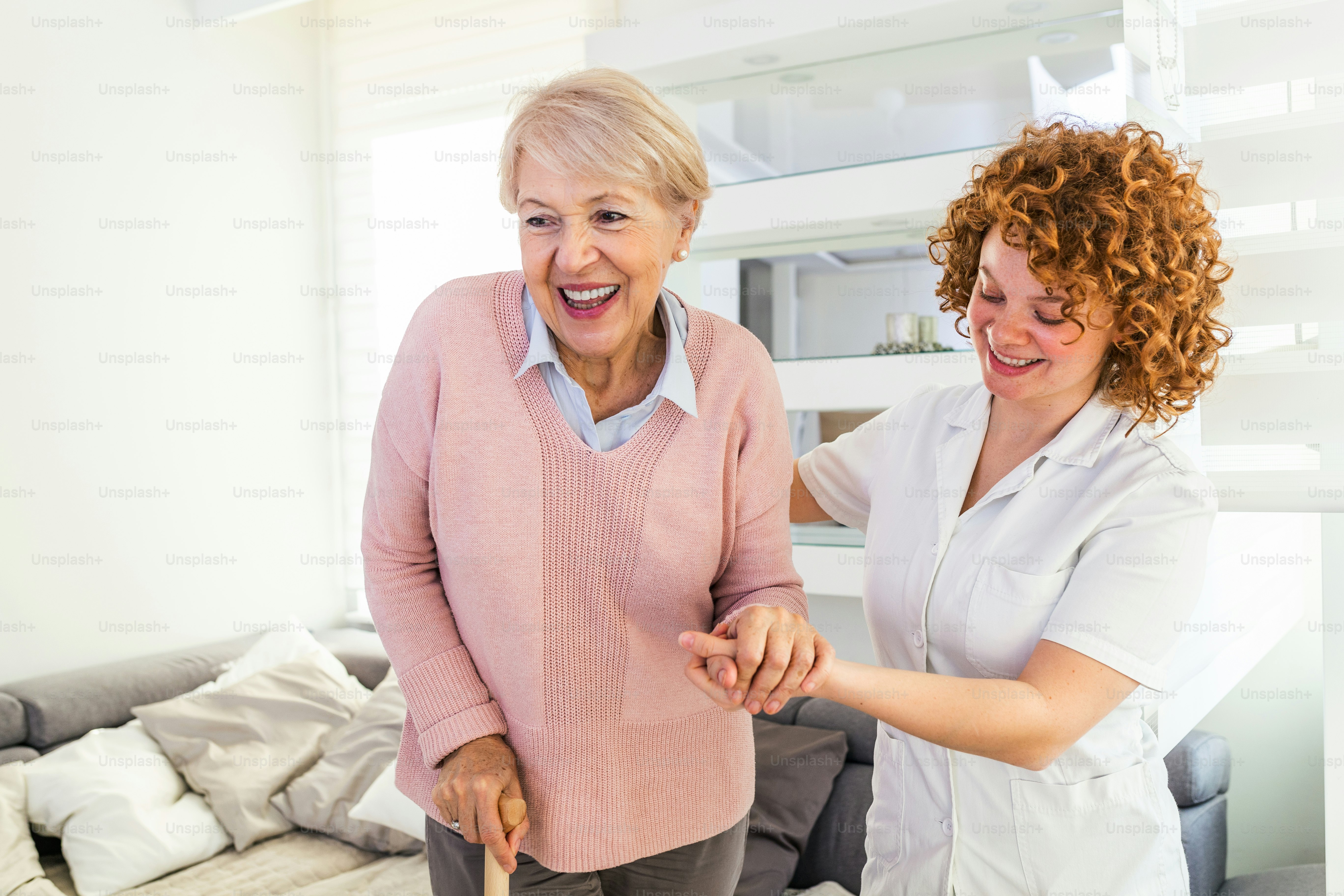 Caregiver supporting a smiling senior at home