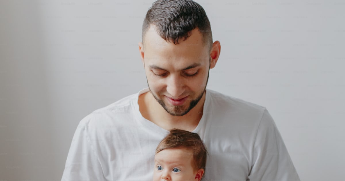 Happy Caucasian father holding newborn baby on laps knees. Man parent ...