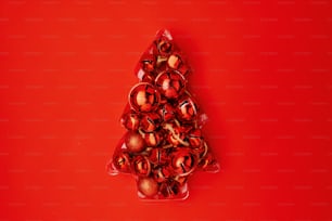 flat lay with christmas tree made from jingle bells on red background.