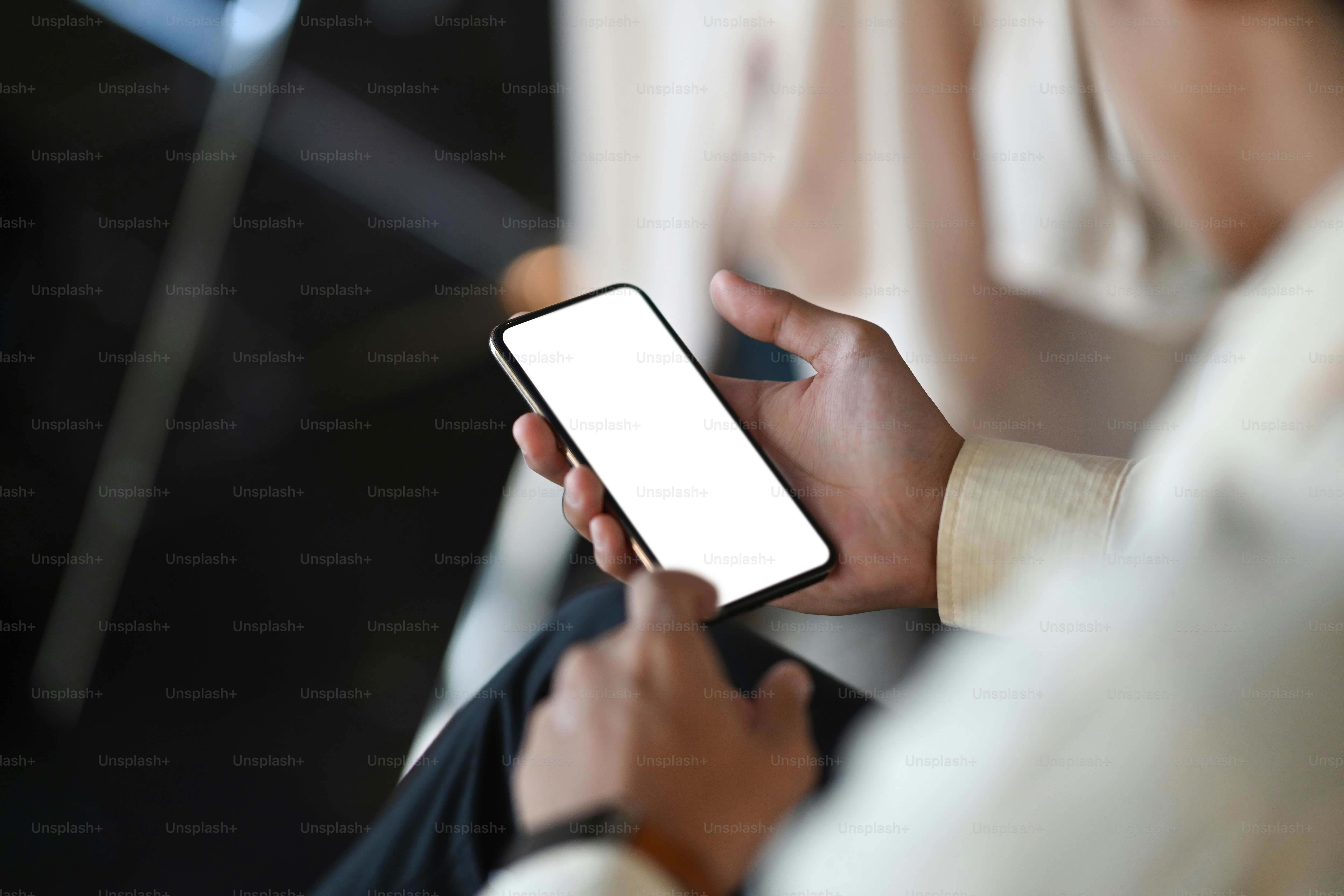 Imagen de las manos del hombre que se sostienen y se tocan en el teléfono móvil de pantalla vacía en la oficina.