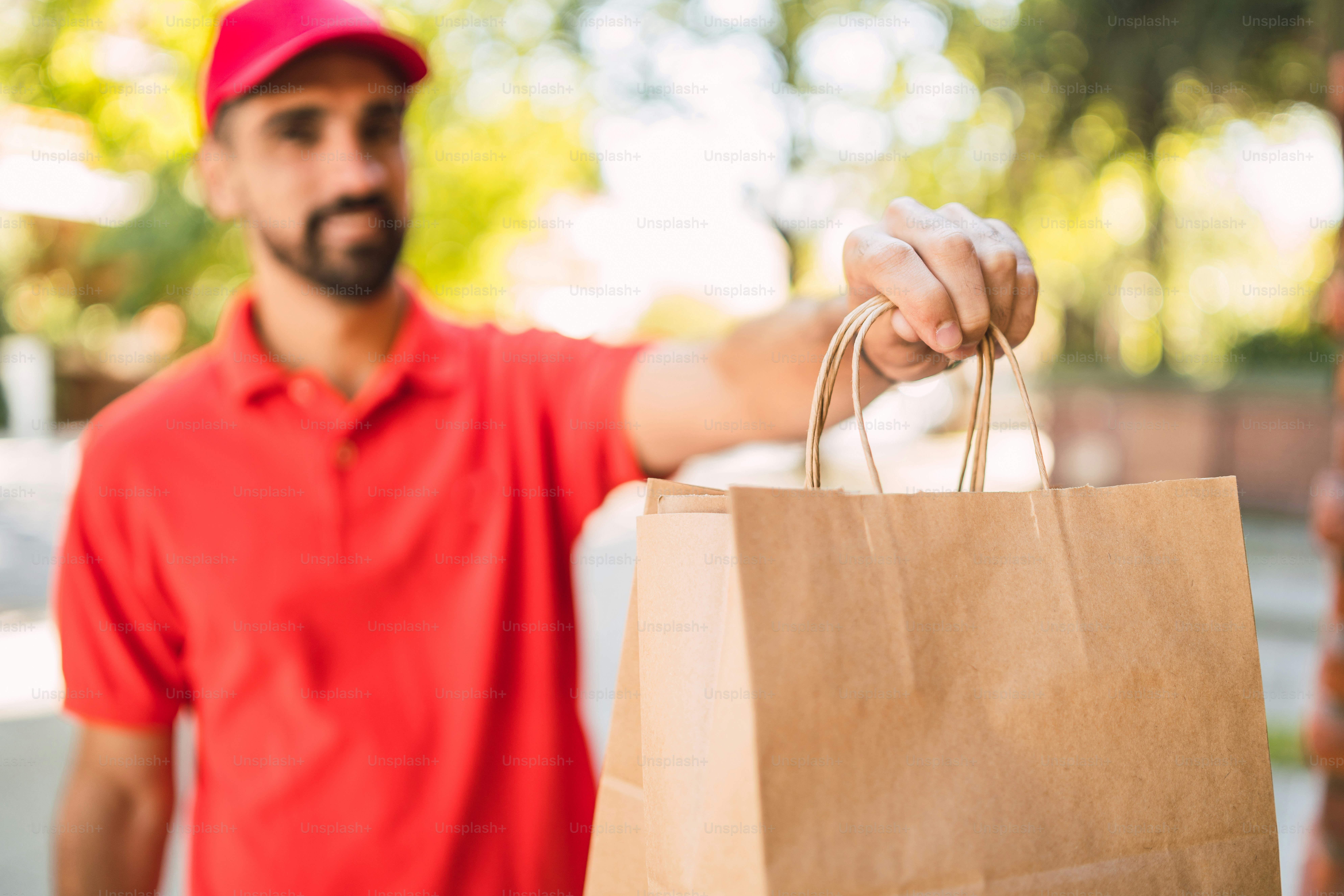 Portrait of a delivery man carrying packages while making home delivery to his customer. Delivery and shipping concept.