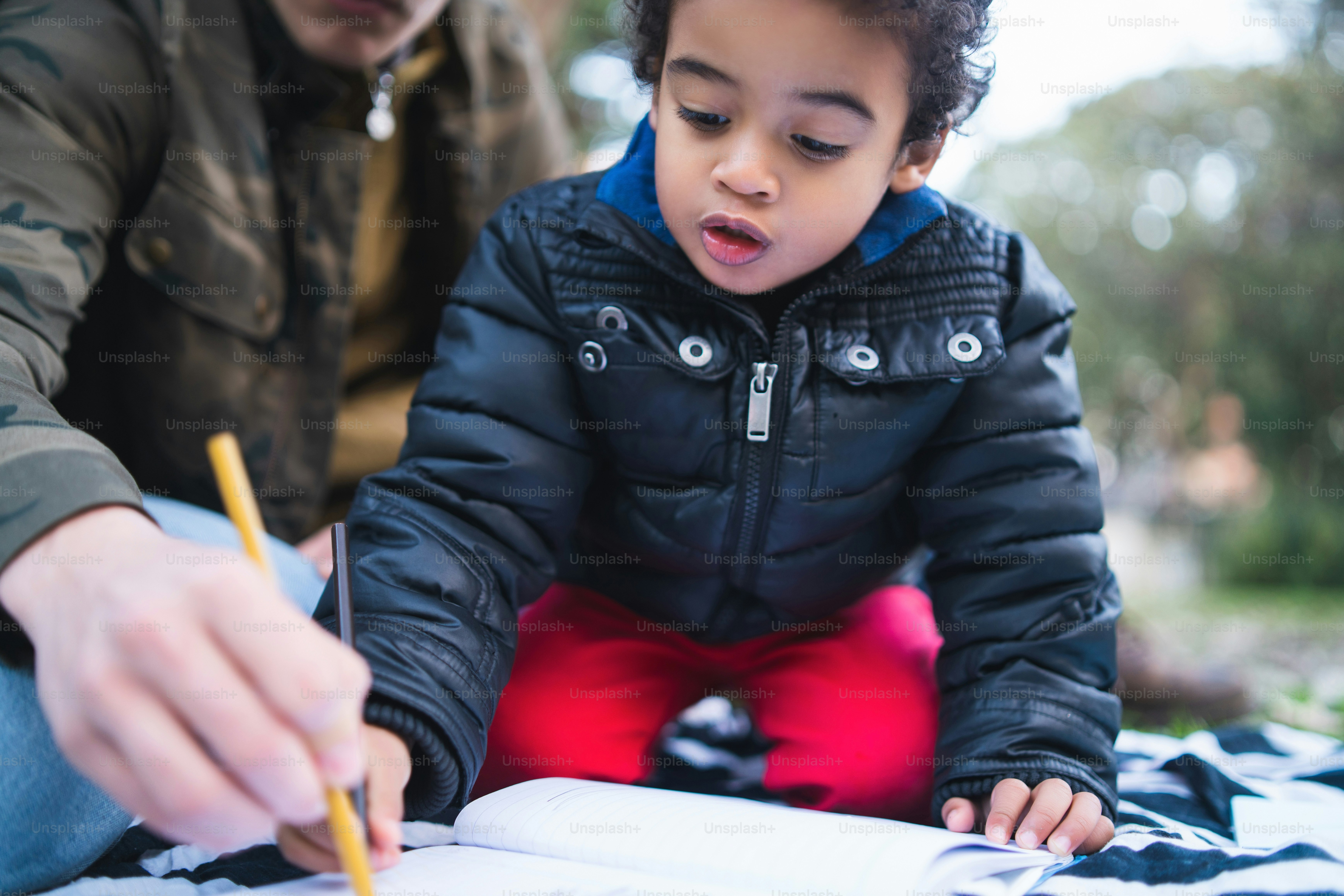 Portrait of an African american little boy playing and having fun with his father outdoors in the park. Monoparental family.