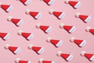 Motif de chapeau de père Noël sur fond rose. Noël, vacances d’hiver, concept du Nouvel An. Style minimaliste.
