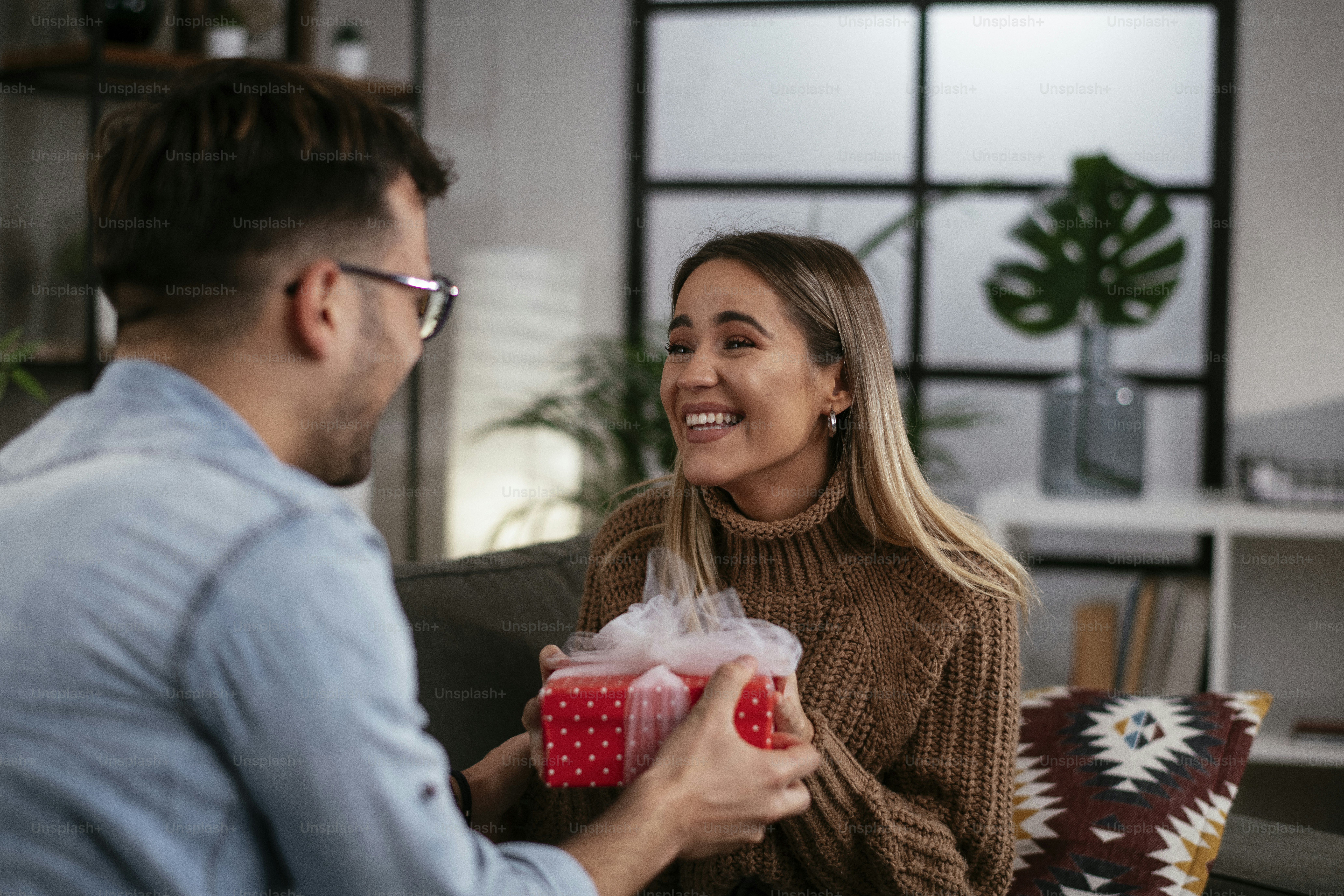 Foto Novio sorprendiendo a su novia con un regalo. Joven dando una caja ...