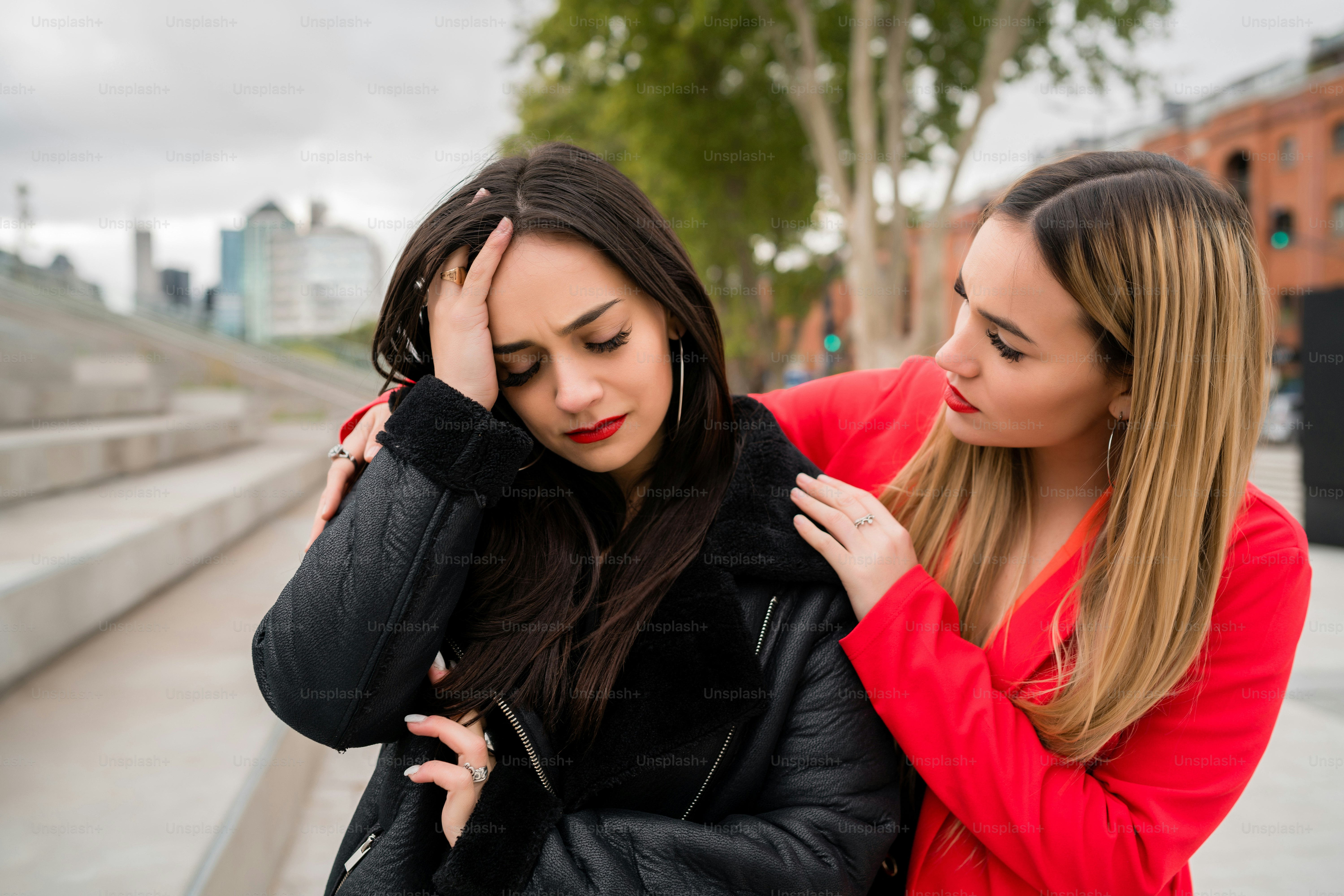 Portrait of a young woman consoling and comforting her upset friend ...