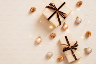 Composizione natalizia moderna. Scatole regalo, palline, ghirlanda su sfondo beige pastello. Stile minimale e scandinavo. Posa piatta.