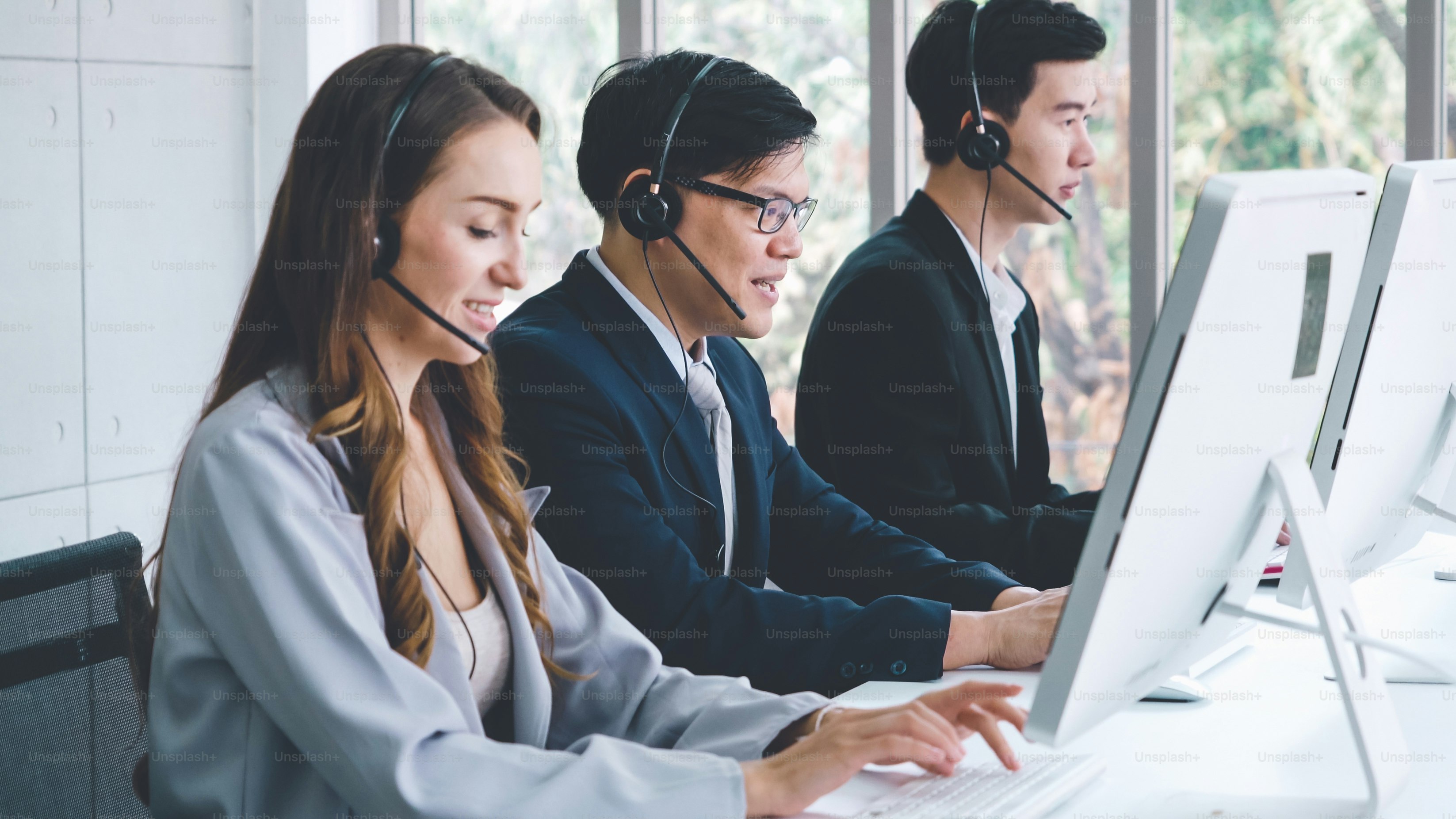 Business people wearing headset working in office to support remote customer or colleague. Call center, telemarketing, customer support agent provide service on telephone video conference call.