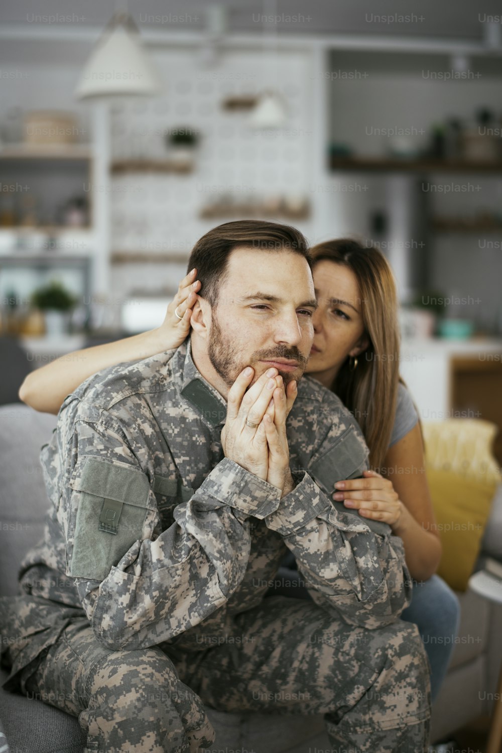 居間のソファーに座る落ち込んだ兵士。PTSDを患っている若い海兵隊員