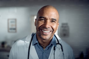 診療所で働き、カメラを見ている幸せな黒人医師の接写。