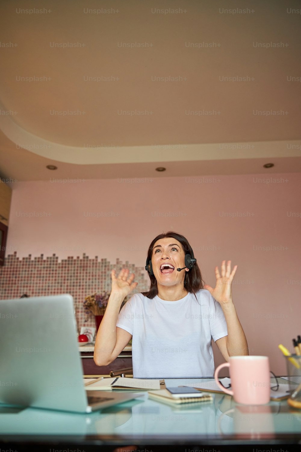Employee raising her hands in the air while opening her mouth and shouting from frustration