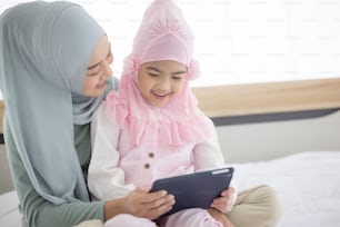 Muslim Mother working with tablet and Cute little baby at home