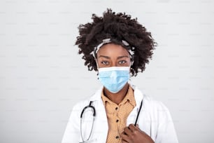 Concepto de medicina, profesión y atención médica - primer plano de la doctora o científica afroamericana en máscara facial protectora sobre fondo gris