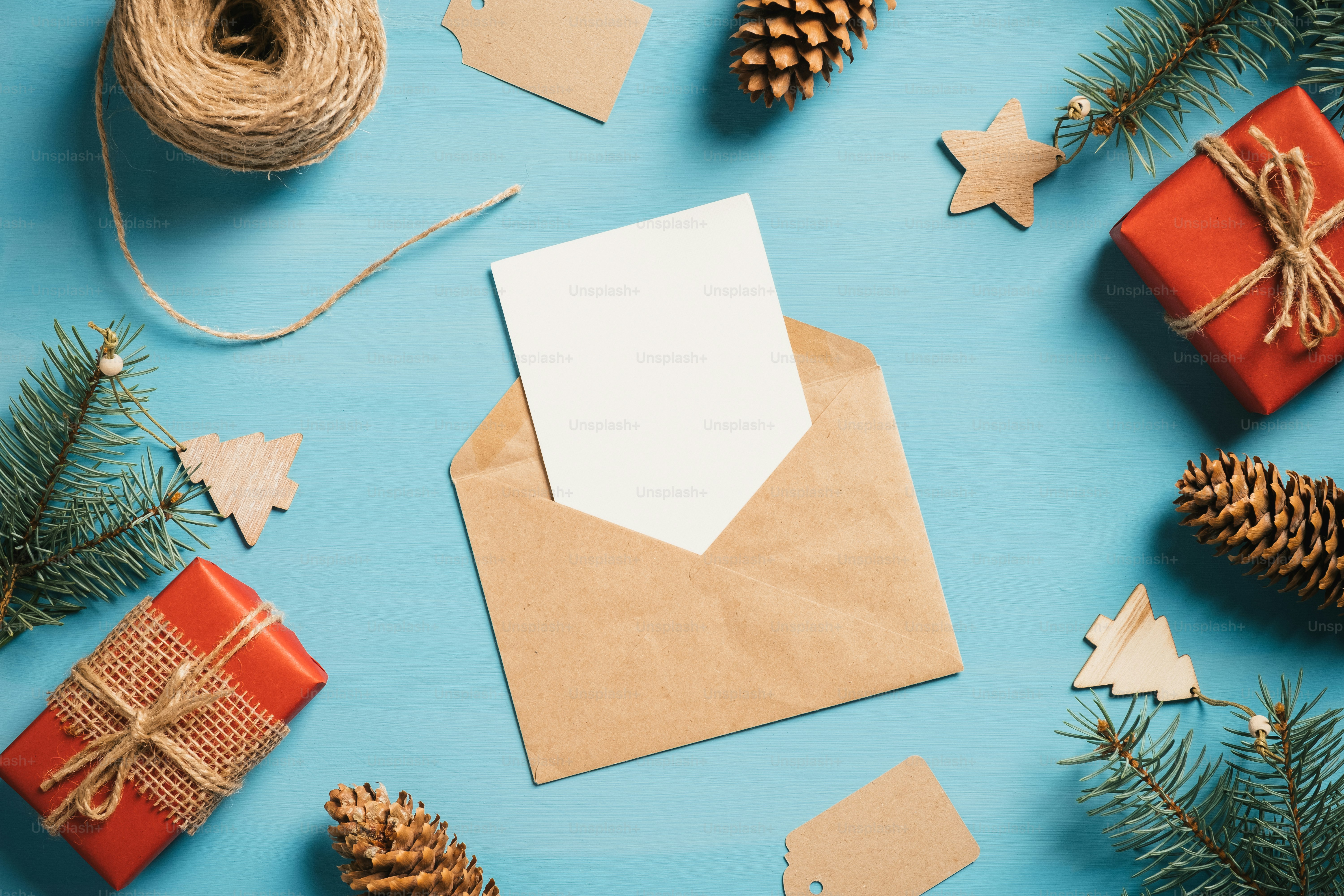 Composición de piso navideño vintage. Tarjeta de papel en blanco, sobre, cajas de regalo, ramas de pino y adornos navideños. Vista superior con espacio de copia. Tarjeta de felicitación de estilo retro.