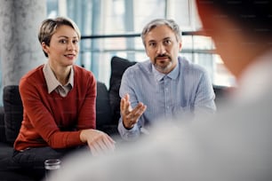 Mid adult couple talking to their financial advisor while having a meeting in the office.