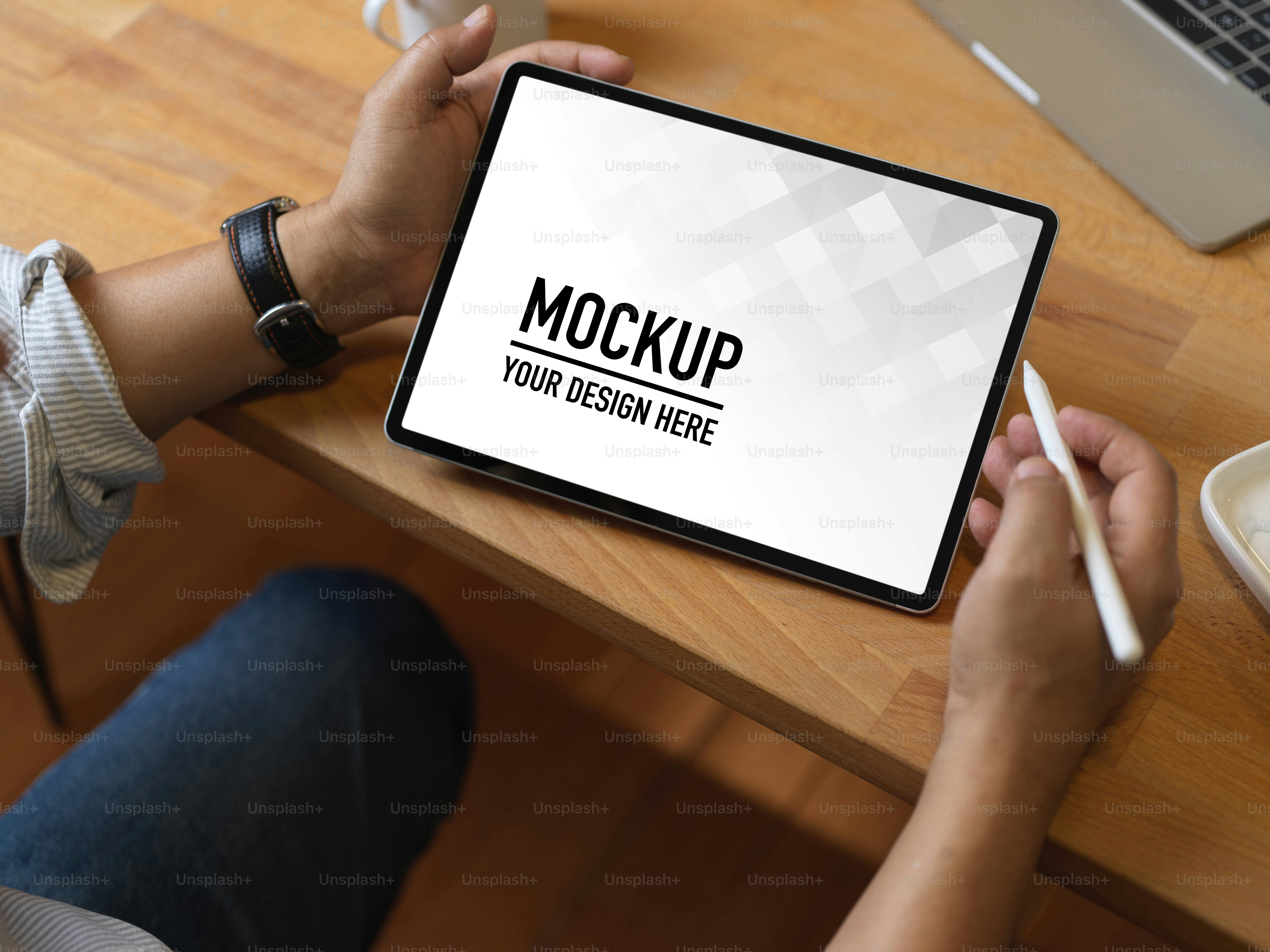 Tampilan dekat tangan laki-laki dengan pena stylus menggunakan tablet digital di atas meja kayu