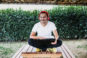 latin man with laptop and headphones at home terrace outdoor in Mexico