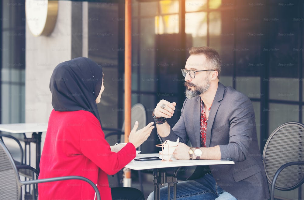 Empresária muçulmana asiática no café conversando com cliente ou namorado