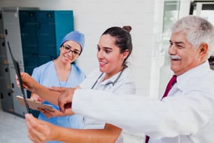 Grupo de médicos latinos buscando una radiografía en un hospital