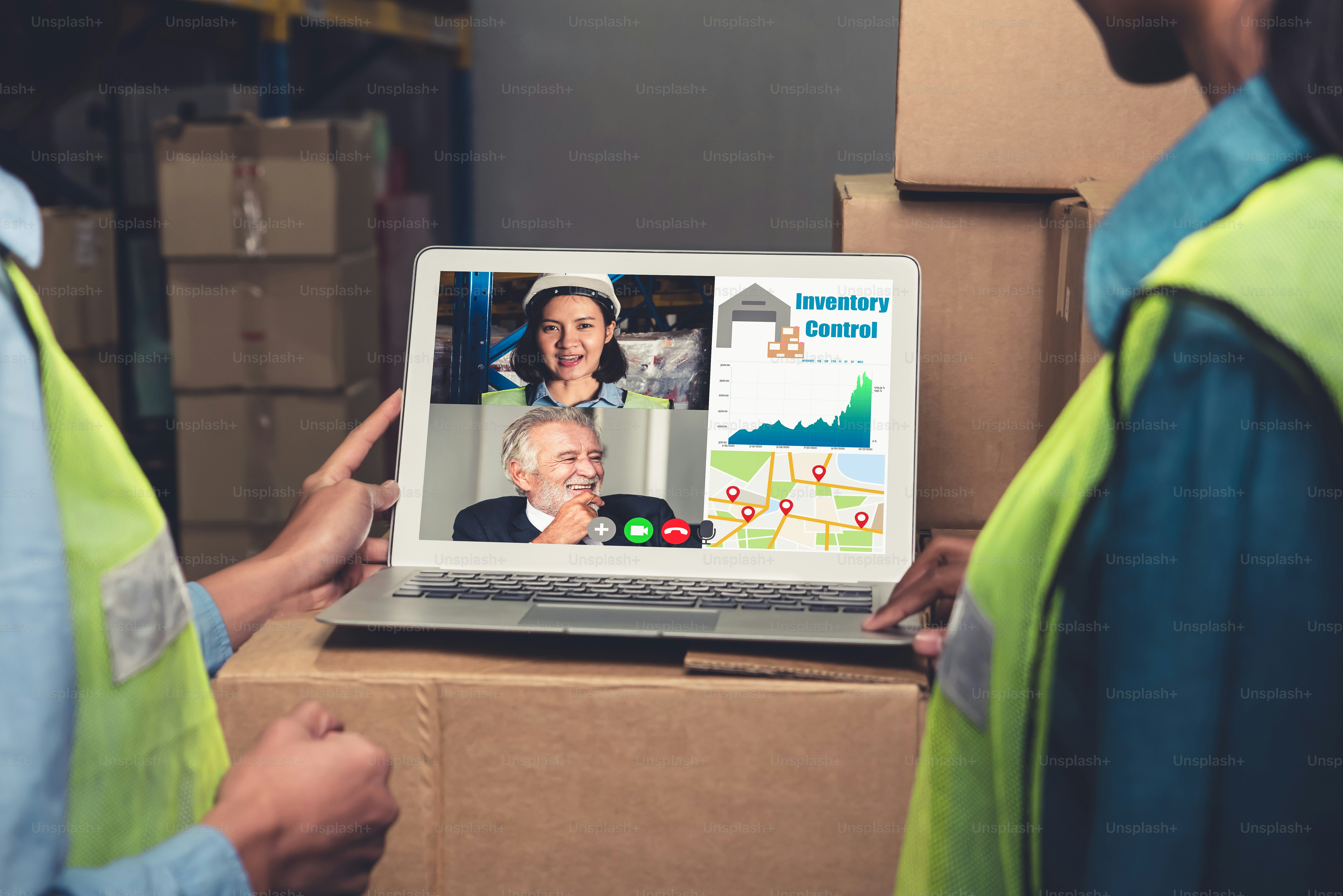 Warehouse staff talking on video call at computer screen in storage ...