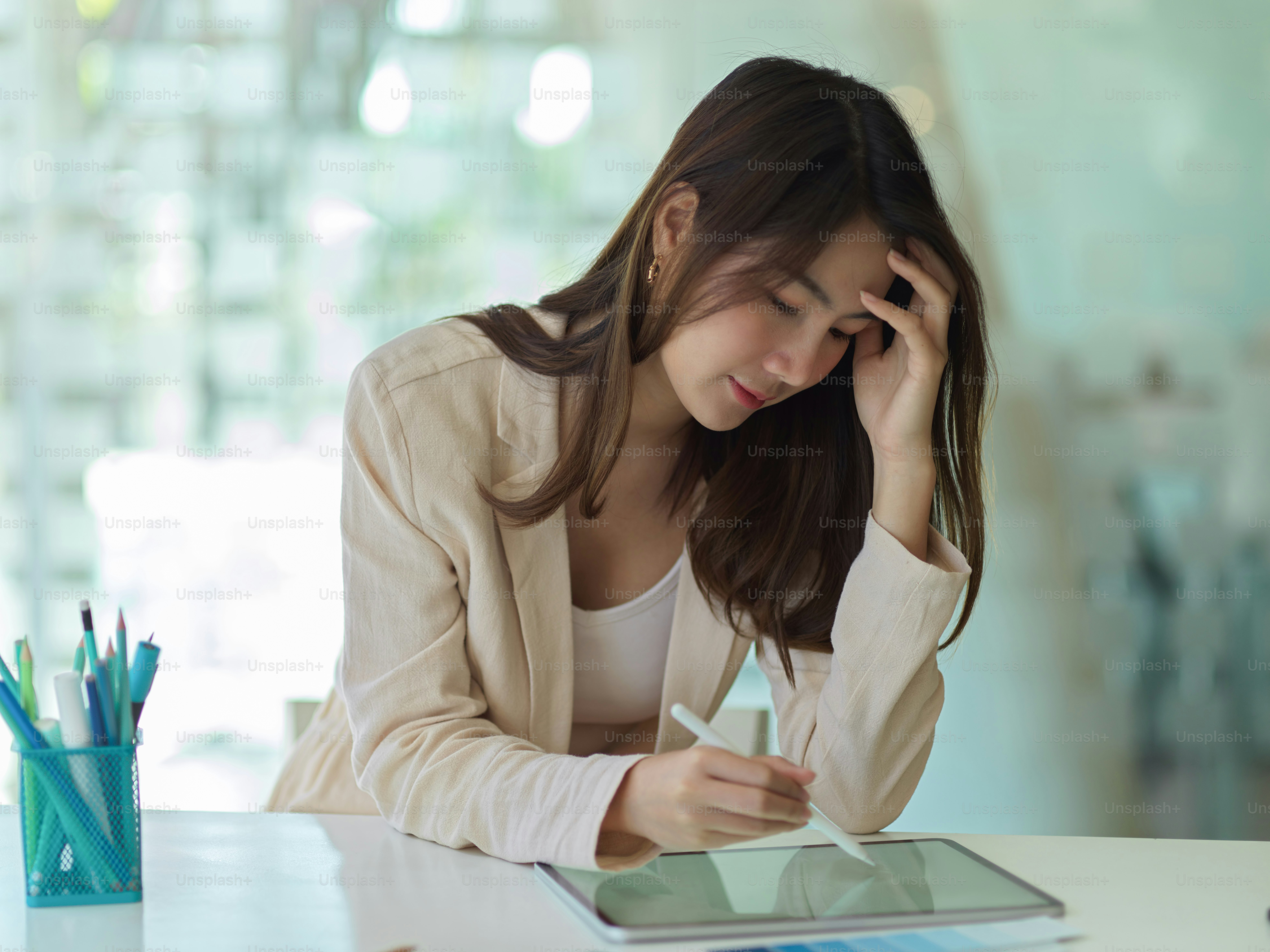 Portrait of businesswoman feeling tried while working with tablet in office room