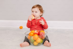 Süßer entzückender kaukasischer Junge, der Zitrusfrüchte isst. Finny Kind isst gesunden Bio-Snack. Festes Fingerfood und Beikost für Kleinkinder.