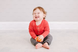 Cute adorable Caucasian baby boy eating citrus fruit. Finny child eating healthy organic snack. Solid finger food and supplementary food for children toddlers.