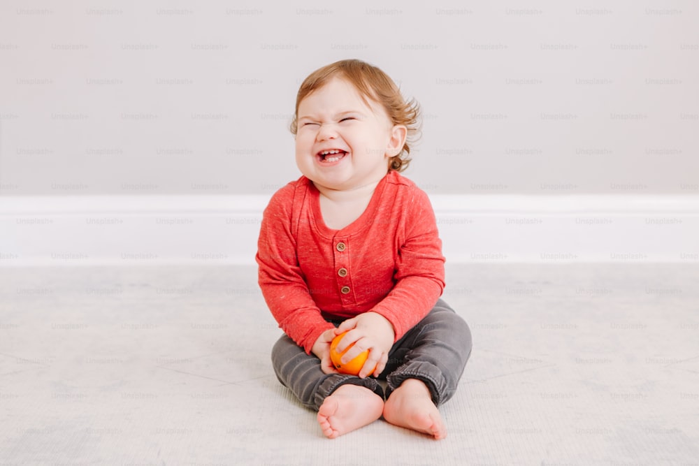 Cute adorable Caucasian baby boy eating citrus fruit. Finny child eating healthy organic snack. Solid finger food and supplementary food for children toddlers.