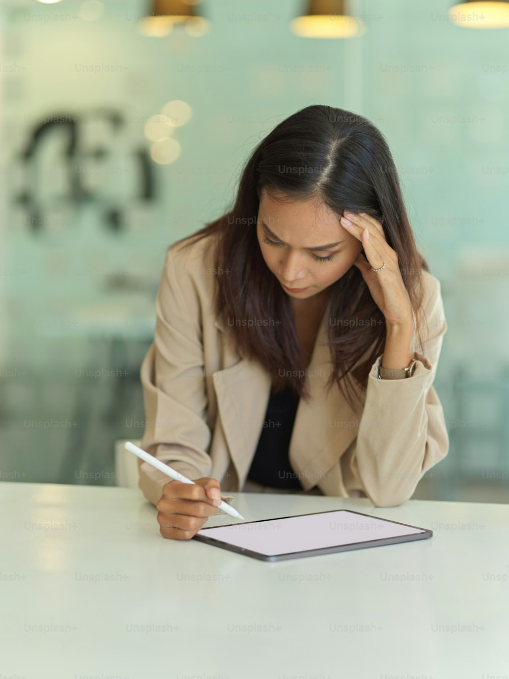 Portrait of seriously young businesswoman working with tablet in office room