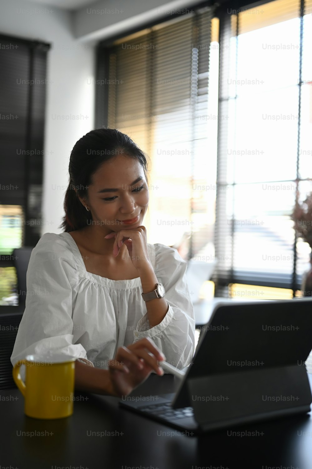 A happy female designer working with computer tablet at her creative office.