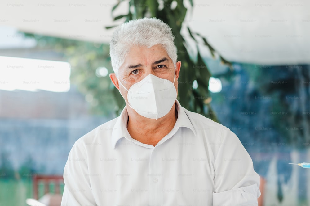 メキシコシティのコロナウイルスパンデミックcovidのワクチンの準備ができているフェイスマスクを持つラテン系の高齢男性