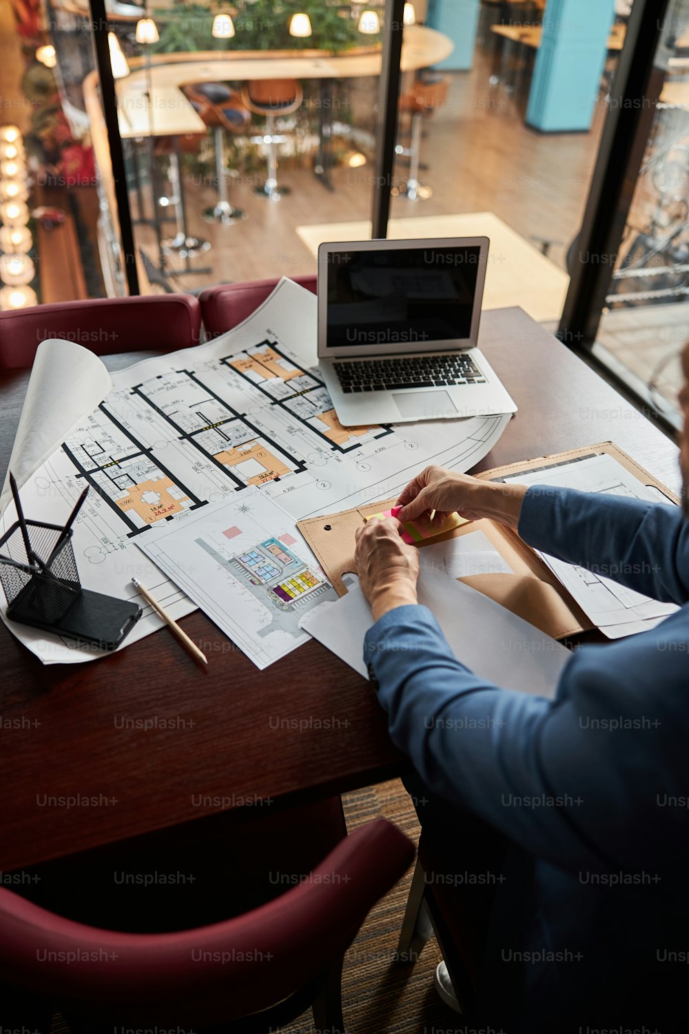 Cropped photo of man using highlight bookmarks while sitting at the office