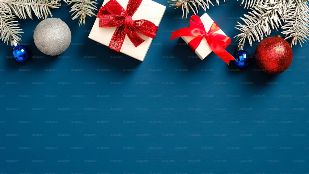 크리스마스 프레임 테두리는 진한 파란색 배경에 공이 있는 선물 상자와 소나무 가지로 만들어졌습니다. 플랫 레이, 평면도. 크리스마스 엽서 템플릿, 새 해 배너 모형.
