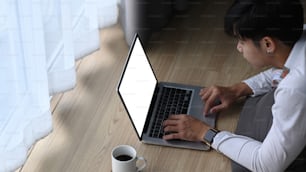 A young man using laptop while lying on floor at home.