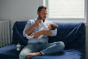 Pai caucasiano orgulhoso com menina recém-nascida. Pai segurando o filho da filha balançando em suas mãos. Autêntico estilo de vida feliz momento paternidade parental. Vida doméstica familiar de pai solteiro.