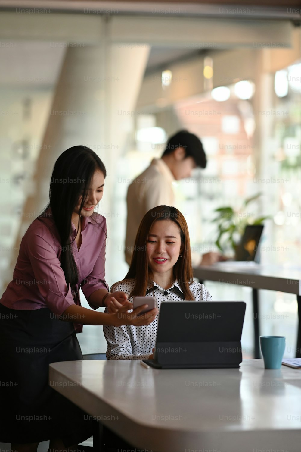 Ritratto di due donne d'affari stanno usando il tablet che discutono la pianificazione di un progetto condiviso nella sala riunioni.