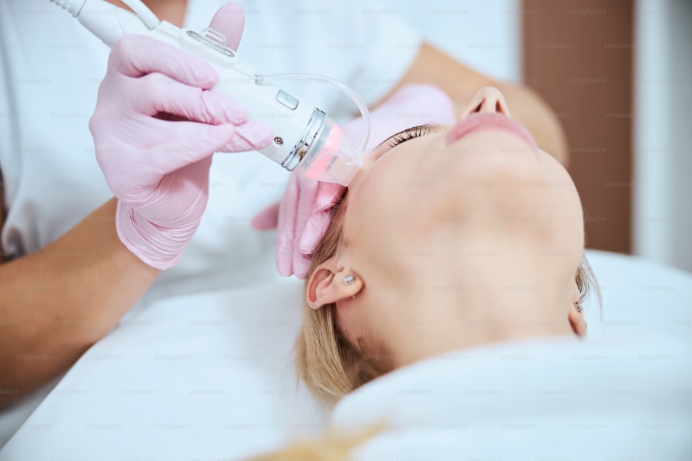 Cropped photo of a skilled dermatologist carrying out a skin rejuvenation procedure on her client