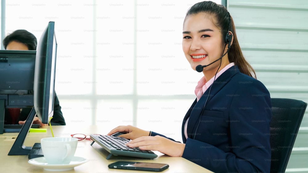 Business people wearing headset working in office to support remote customer or colleague. Call center, telemarketing, customer support agent provide service on telephone video conference call.