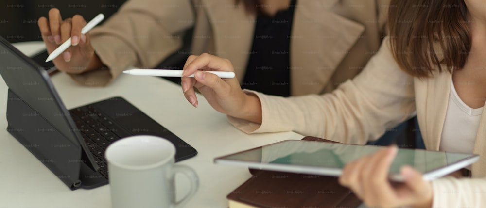 Cropped shot of businesswomen consulting on their project with tablet in meeting room