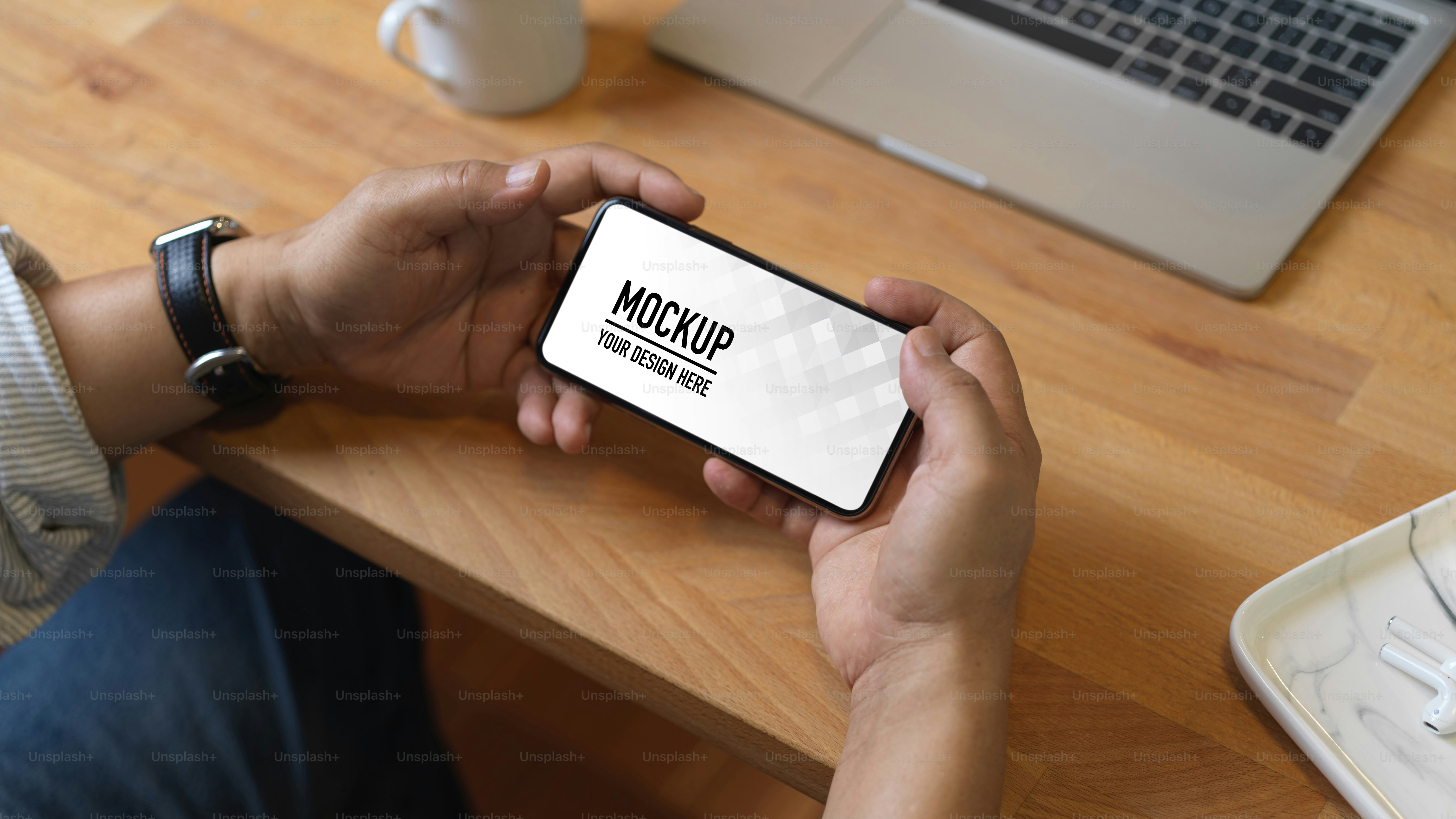 Close up view of male hands using horizontal smartphone on wooden worktable, clipping path