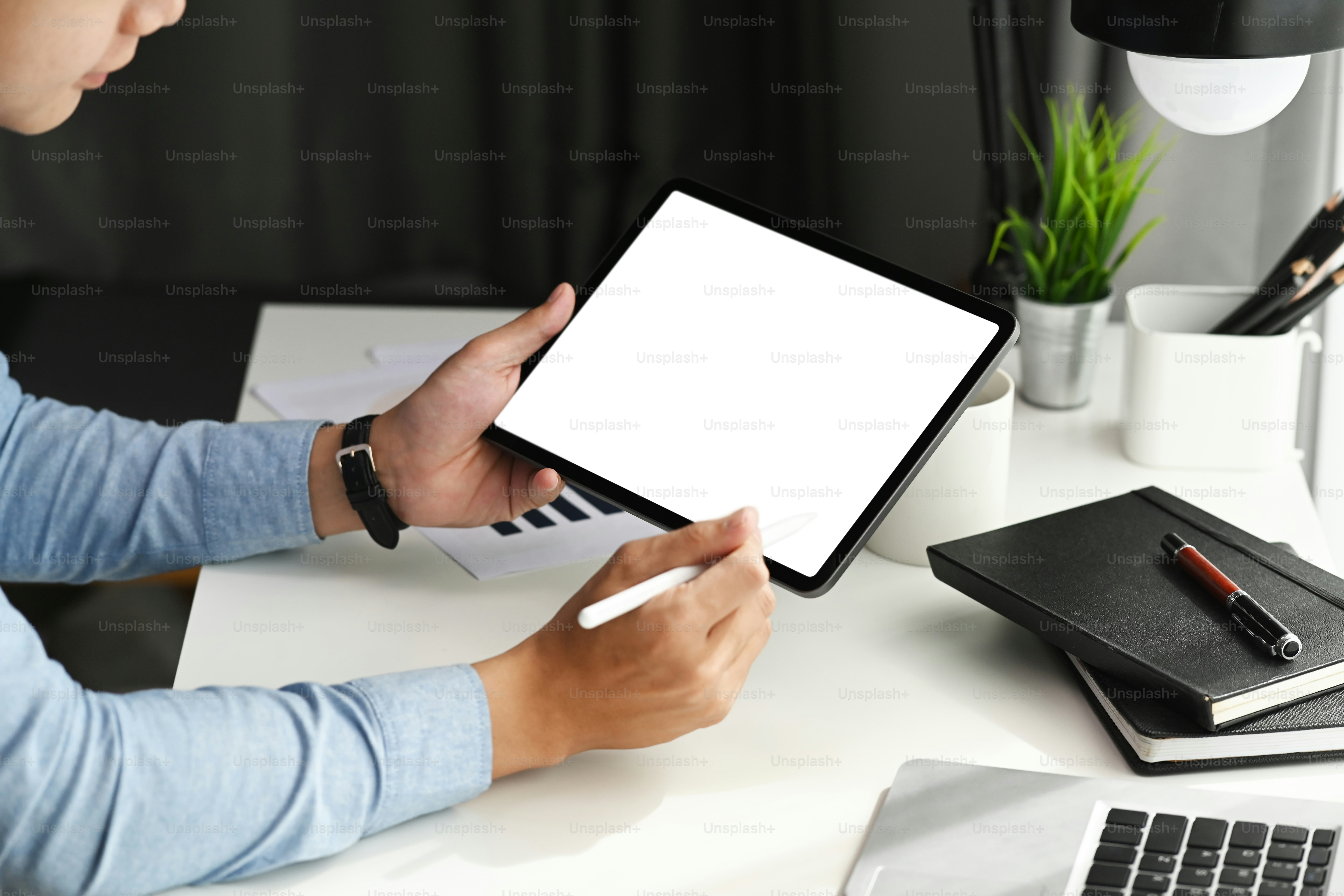 Cropped shot of graphic designer using stylus pen pointing on tablet. Blank screen for product montage.