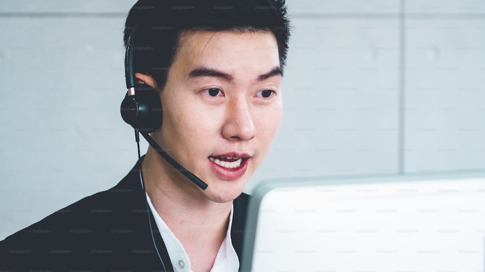 Business people wearing headset working in office to support remote customer or colleague. Call center, telemarketing, customer support agent provide service on telephone video conference call.