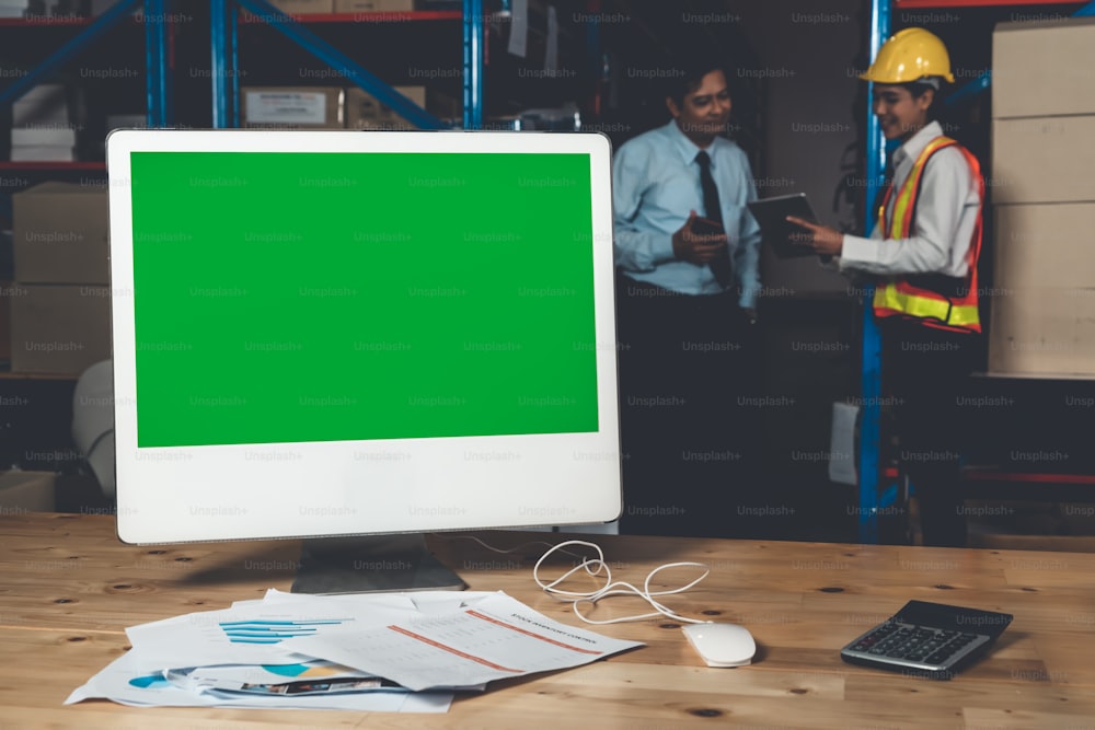 Computer with green screen display in warehouse storage room . Delivery and transportation software concept .